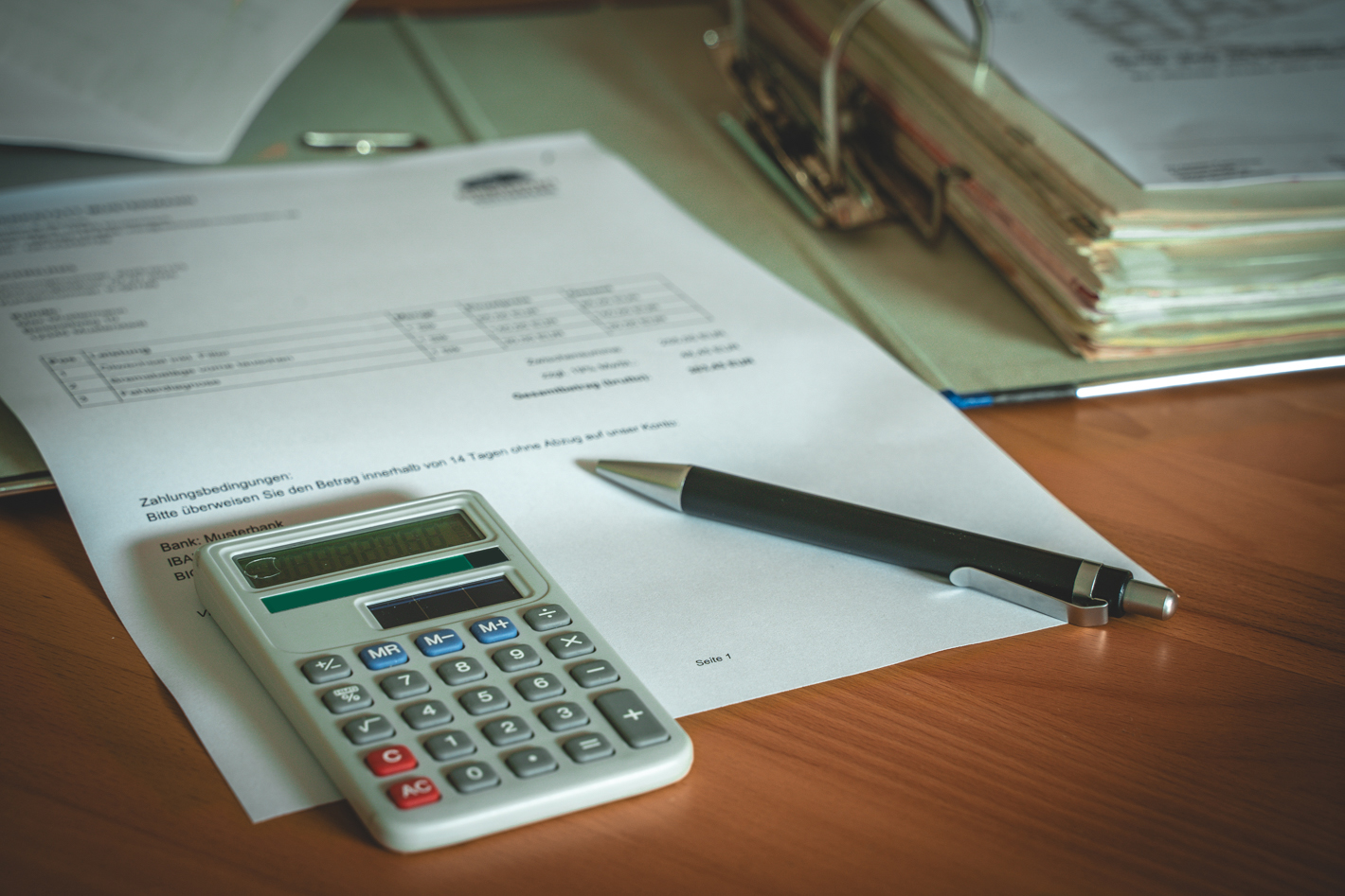 folder with bills, calculator and pen